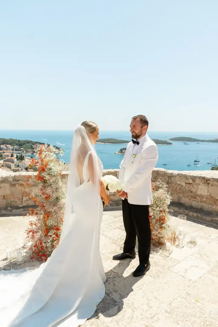 Couple standing on a romantic stone wall in Croatia with the Adriatic Sea in the background
